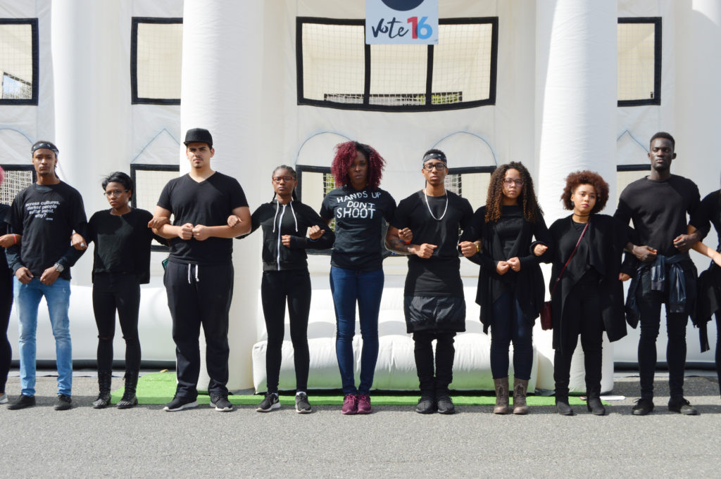 Students from the Black Student Union link arms in front of a White House bounce castle in protest of the fatal shootings of black Americans by police. (Photo by Cam Keough/The Chronicle)