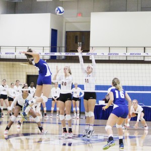 Kevin Gomes/The Chronicle  Leticia Valente rises up to spike the ball as two Charleston players try to block.